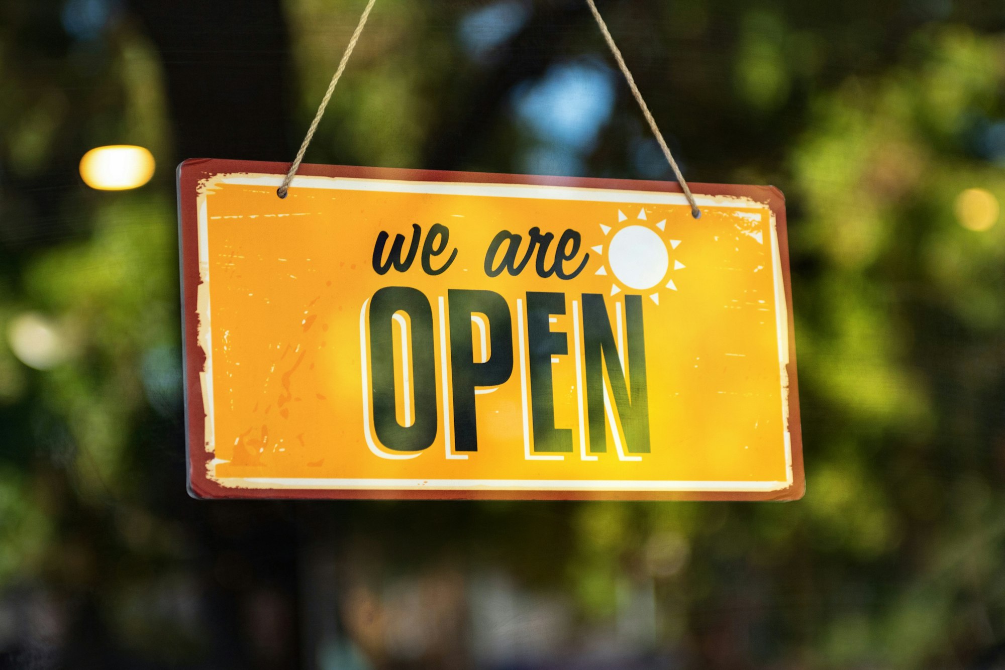 A local shop door sign reading Come In We Are Open